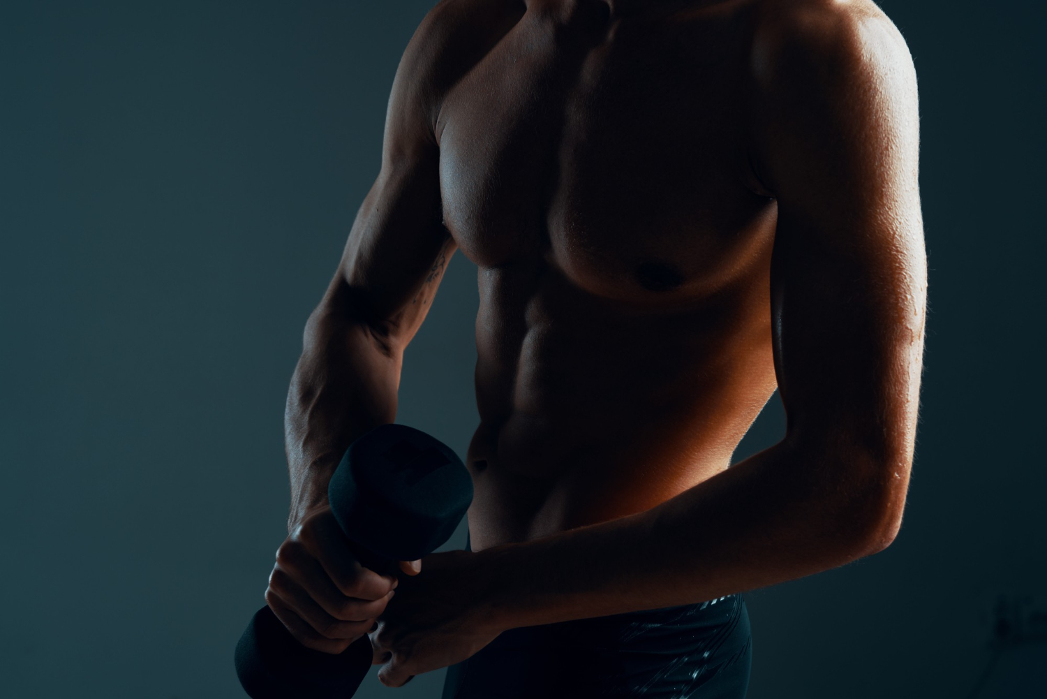 young teenage male with pumped abdominals exercising during workout