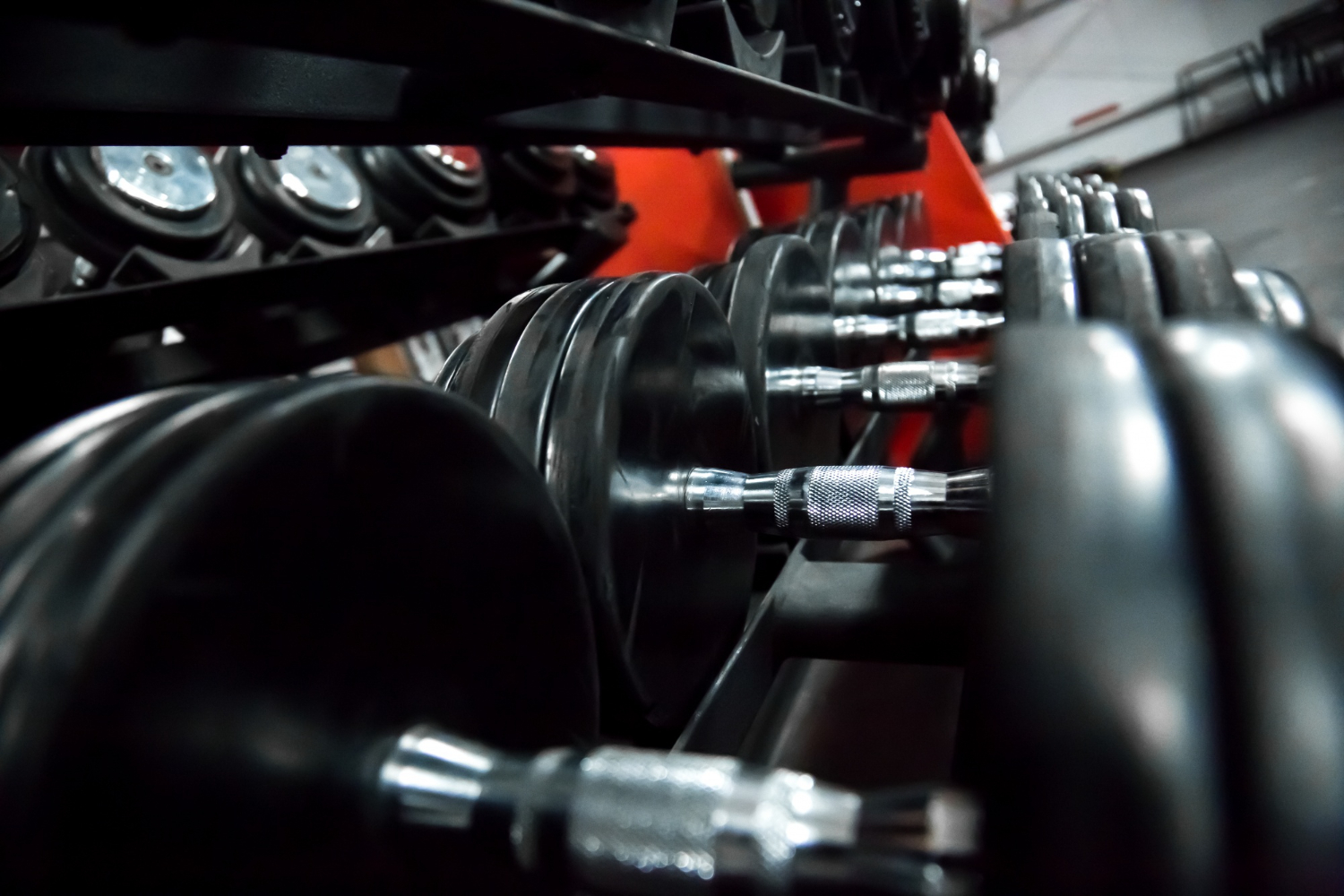 many black dumbbells on a rack for bodybuilding in gym
