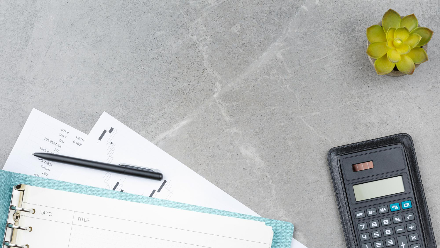 calculator and budget plan with pen on flat marble surface