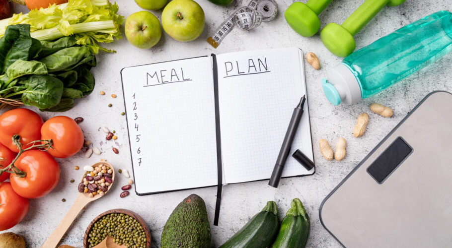 meal plan notepad with healthy sports food and equipment