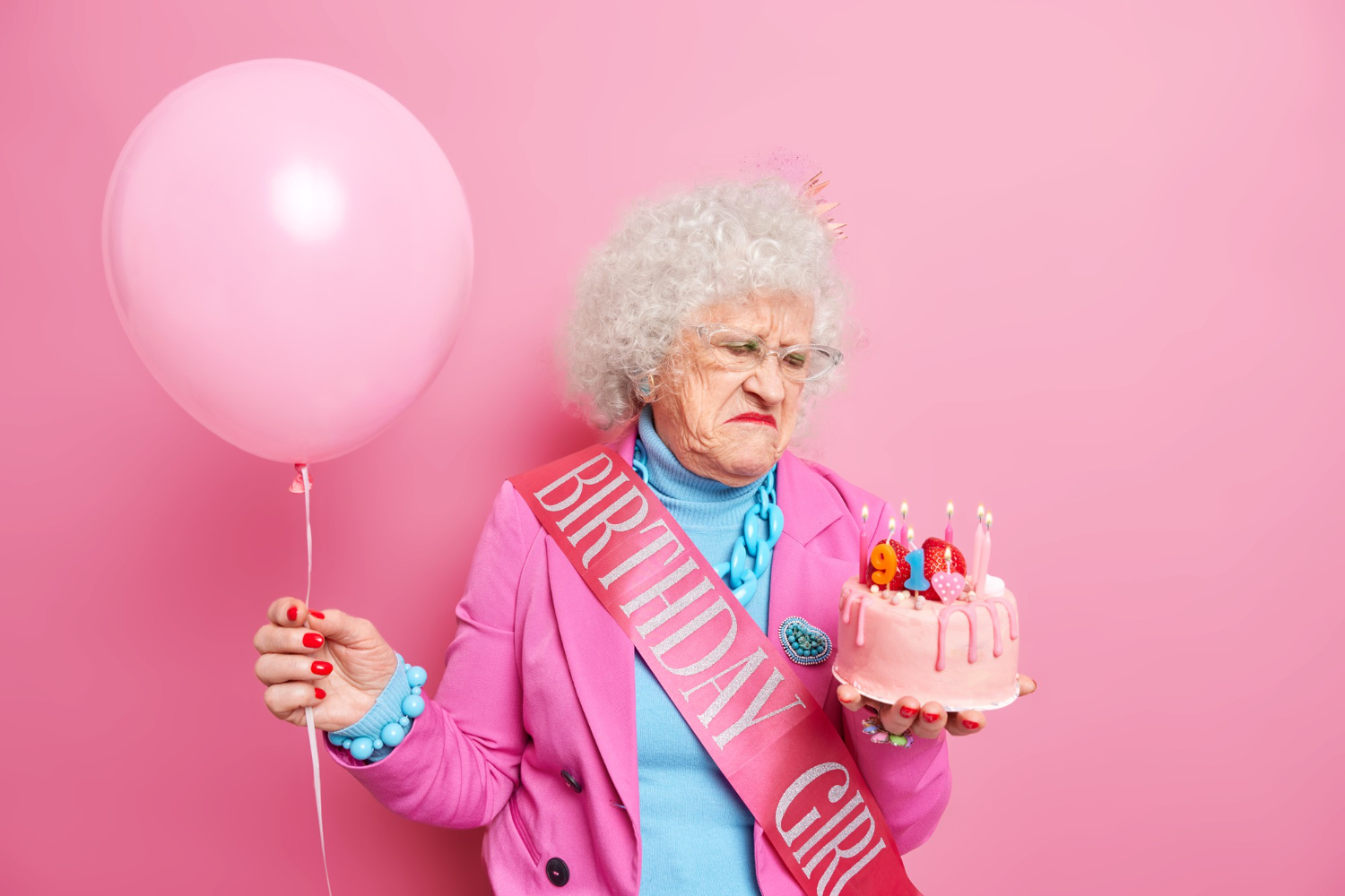 old grey haired beautiful woman looks displeased birthday cake festive outfit holds inflated balloon