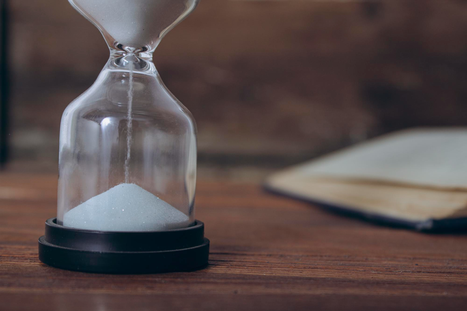 open book hourglass wooden table