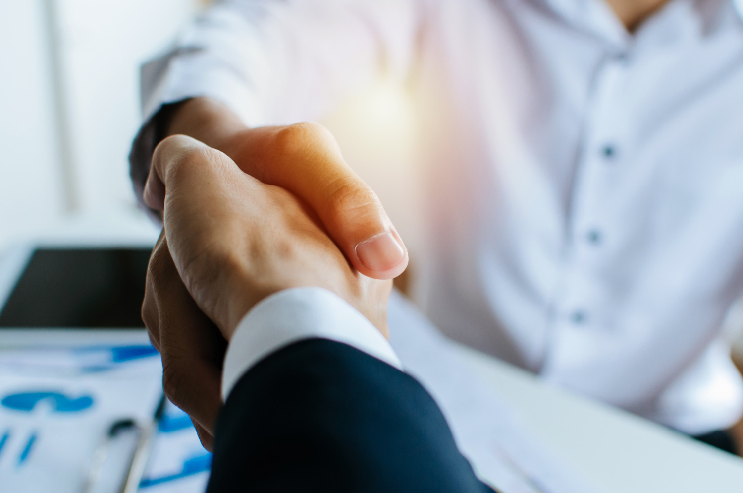 partnership as two business people shake hands after a job interview in a meeting room