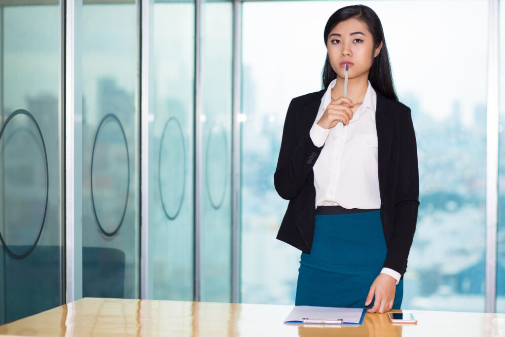 pensive attractive asian business woman desk 
