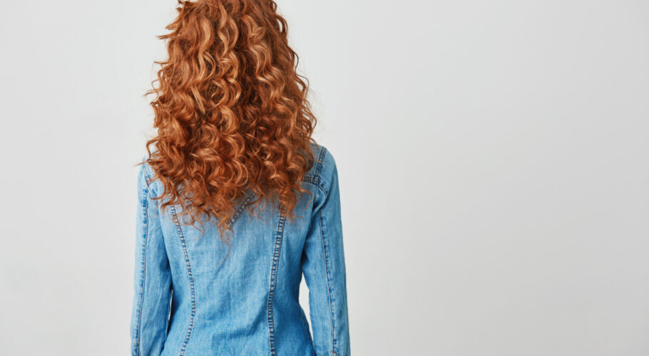 girl with red curly hair kathryn standing with back to camera