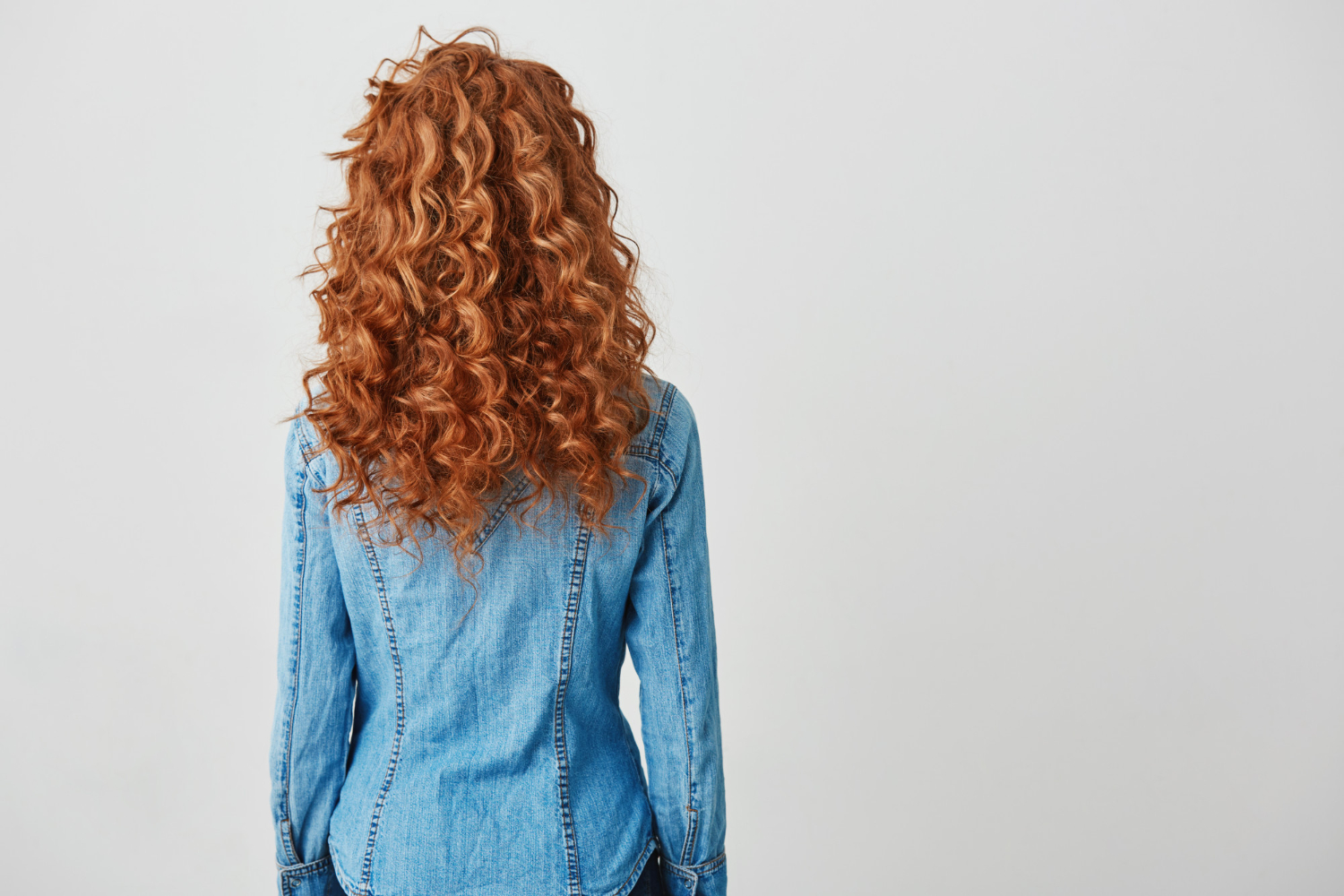 girl with red curly hair kathryn standing with back to camera