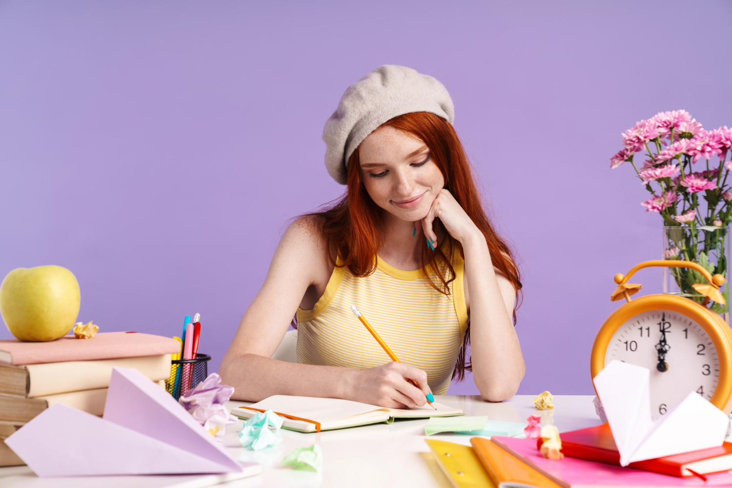 Kathryn writing a letter in notepad smiling thinking