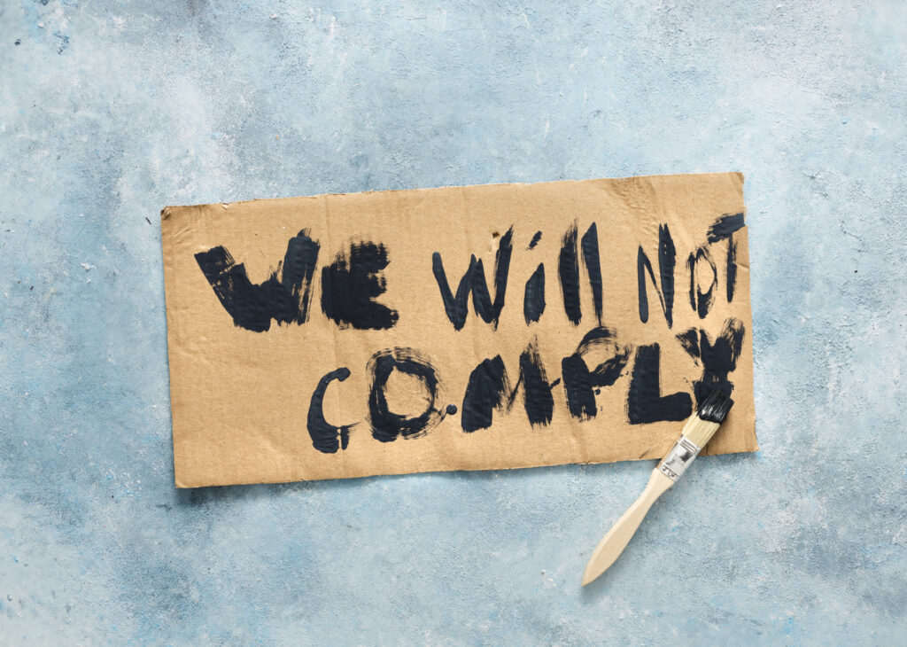 We Will Not Comply COVID-19 Phrase Written On Cardboard Top View