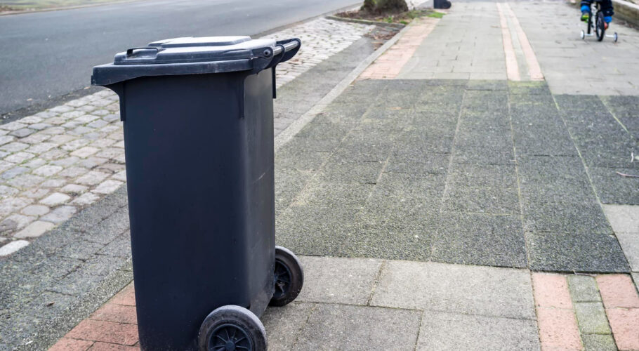 plastic dumpster otto bin stands on the side of the road waiting for garbage truck