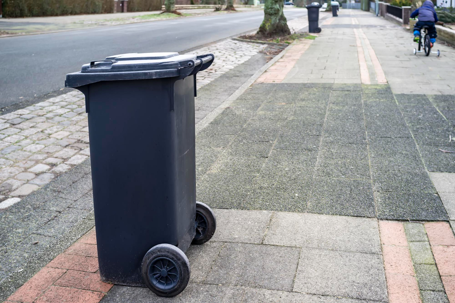 plastic dumpster otto bin stands on the side of the road waiting for garbage truck