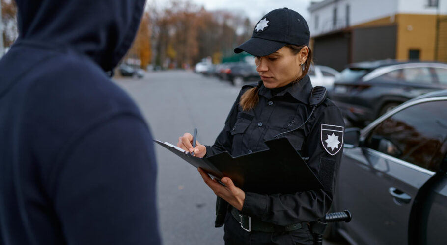 police woman issues a fine to a male cyclist
