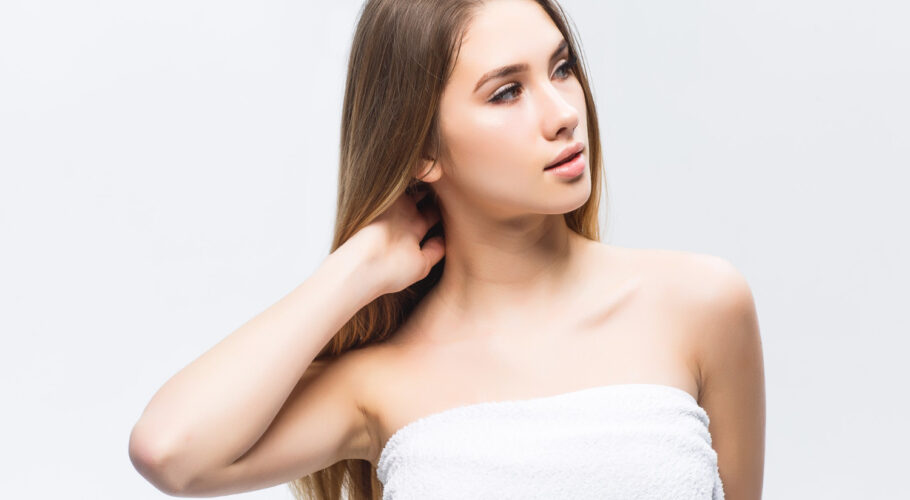 portrait attractive young woman madlyn touching smooth healthy skin her face looking away against white wall