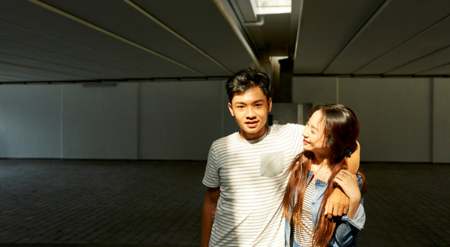 portrait happy young asian chinese couple love hugging when standing sunrays underground