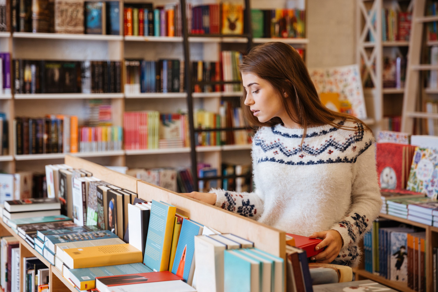 young woman casually searching books in the bookstore