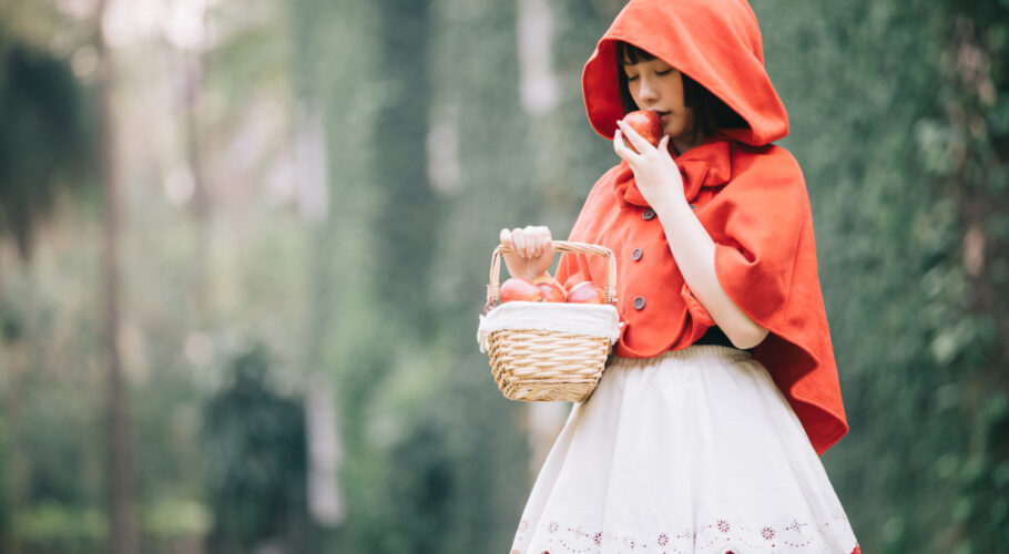 young Asian woman with little red riding hood clothes feeling safe or in danger
