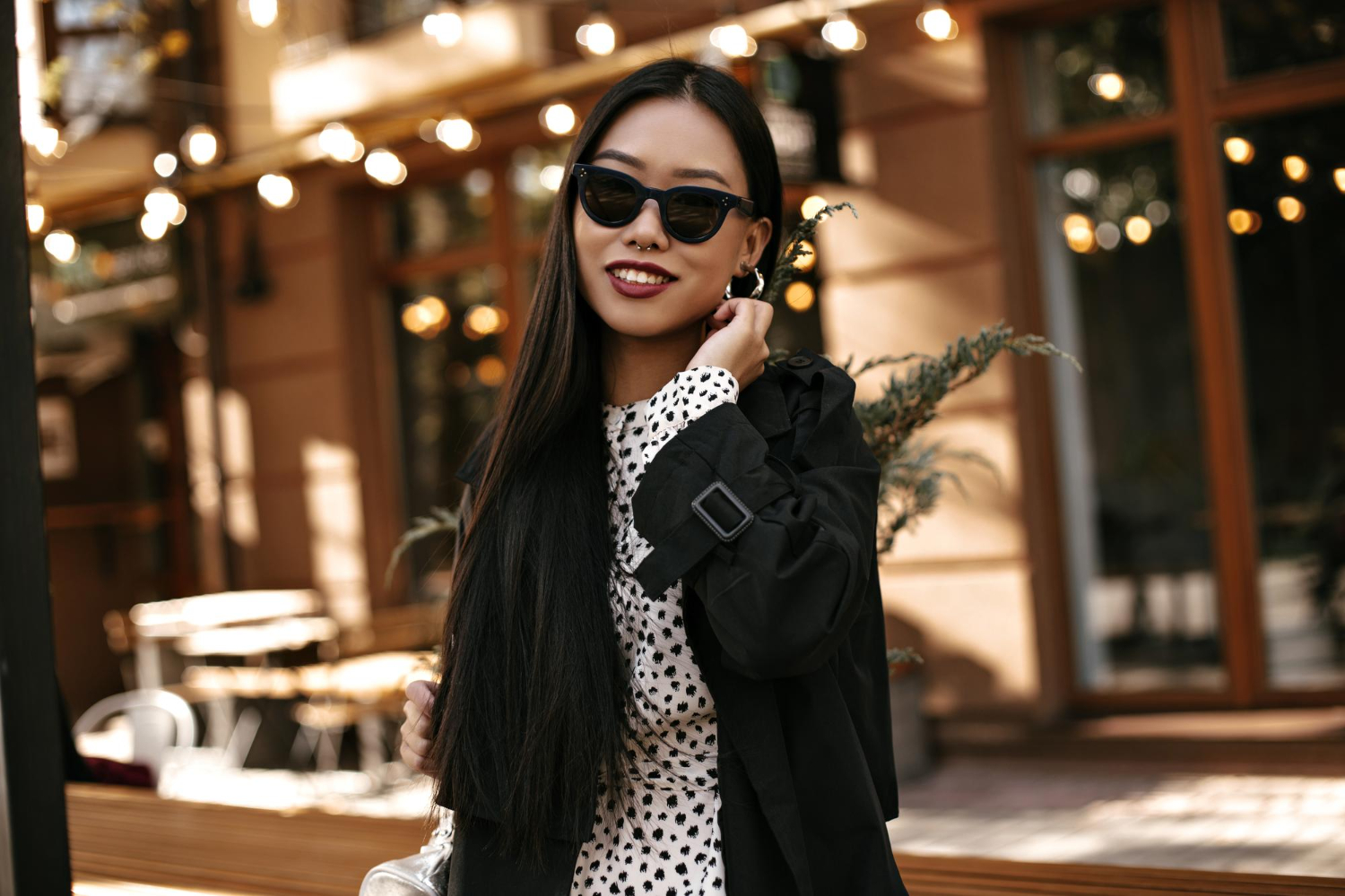 pretty young woman black trench coat polka dot dress asian lady sunglasses poses outside