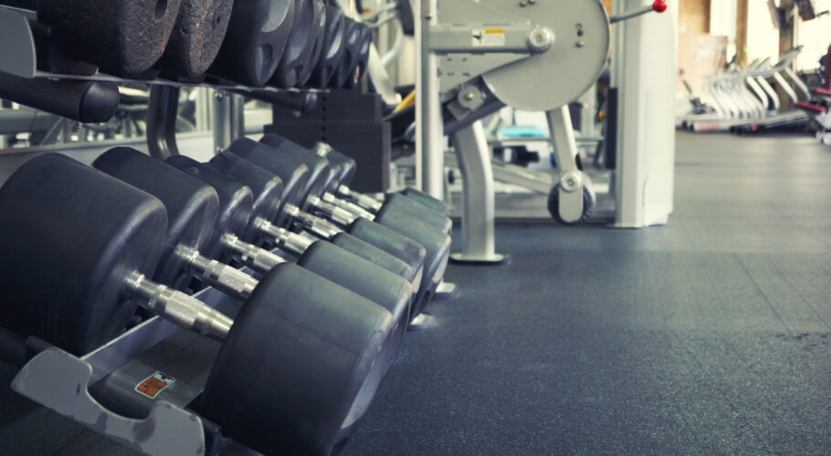 rows of dumbbells in empty gym with treadmills