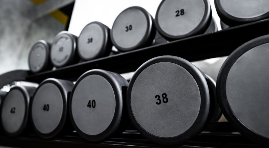 rows of metal dumbbells rack in bodybuilding gym
