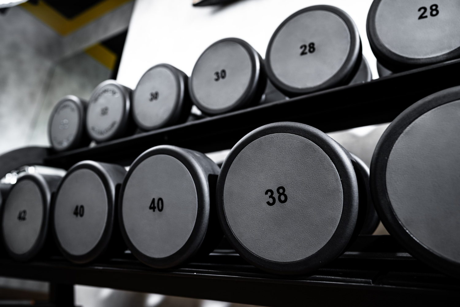 rows of metal dumbbells rack in bodybuilding gym
