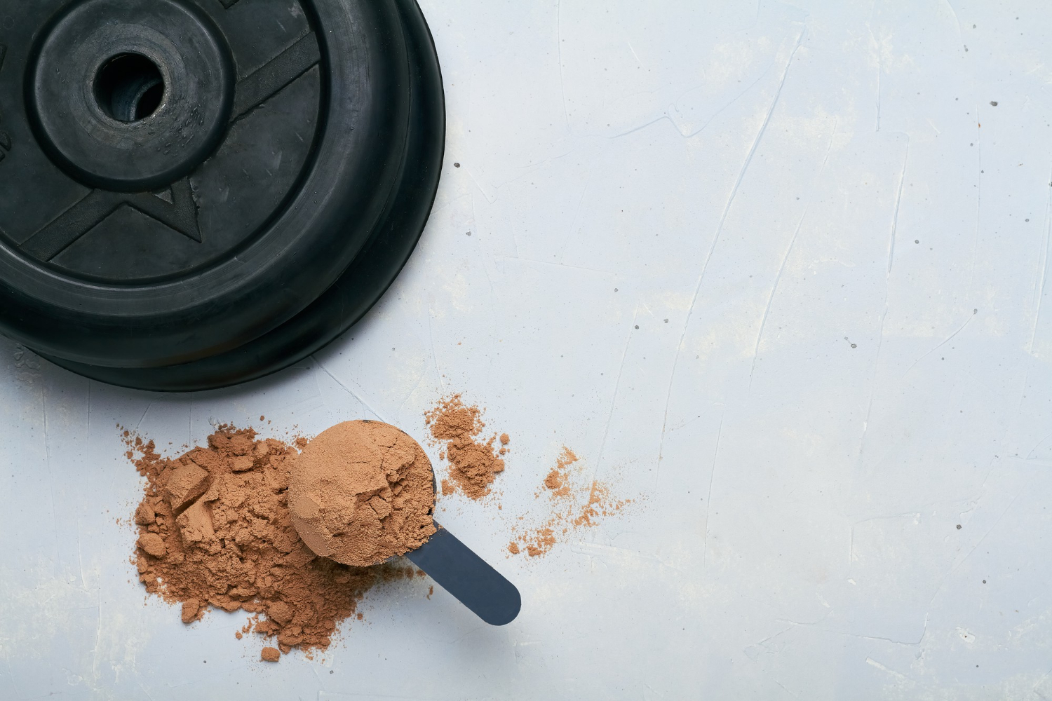 scoop of protein powder and weight plates