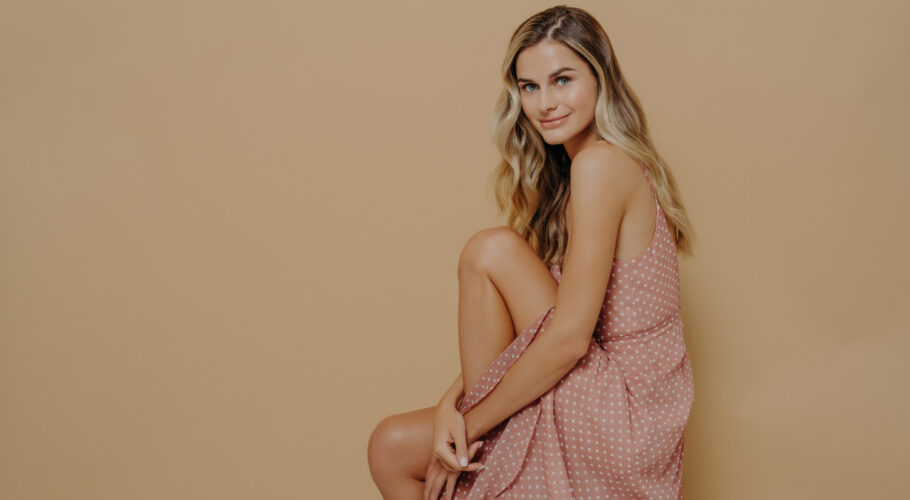 young woman carey summer dress sitting sideways on a chair