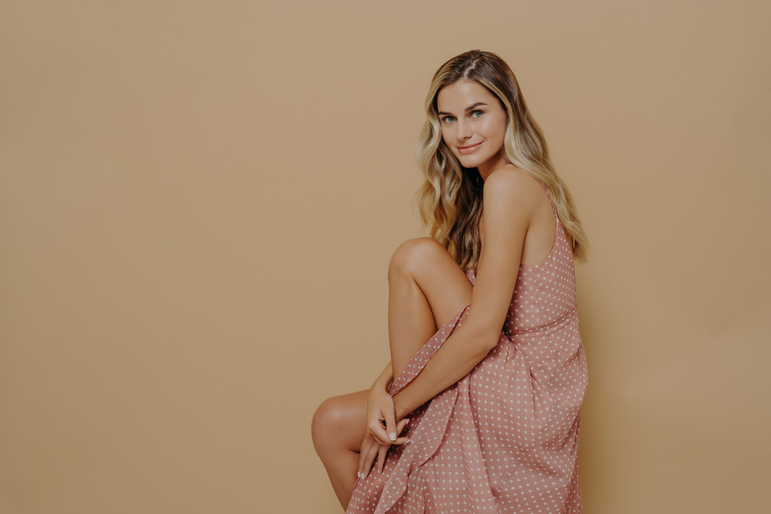 young woman carey summer dress sitting sideways on a chair