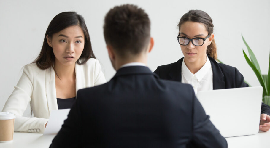 serious unconvinced hr managers interviewing male job applicant