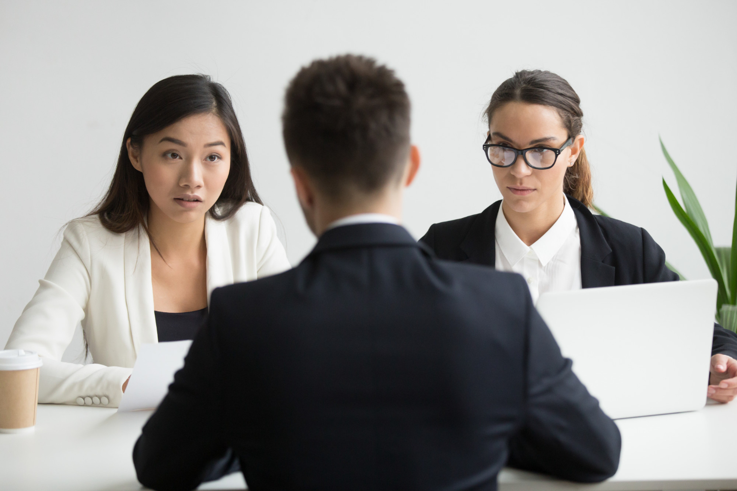 serious unconvinced hr managers interviewing male job applicant