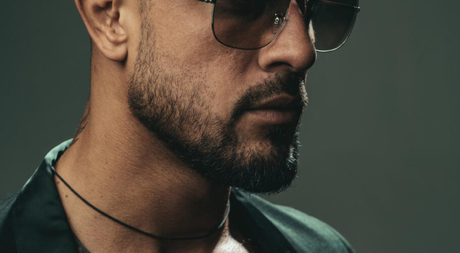 sexy bearded tattooed man wearing sunglasses dramatic face