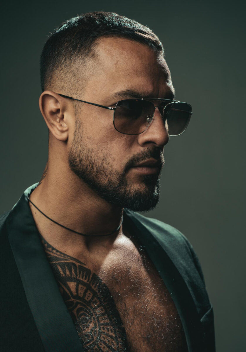 sexy bearded tattooed man wearing sunglasses dramatic face