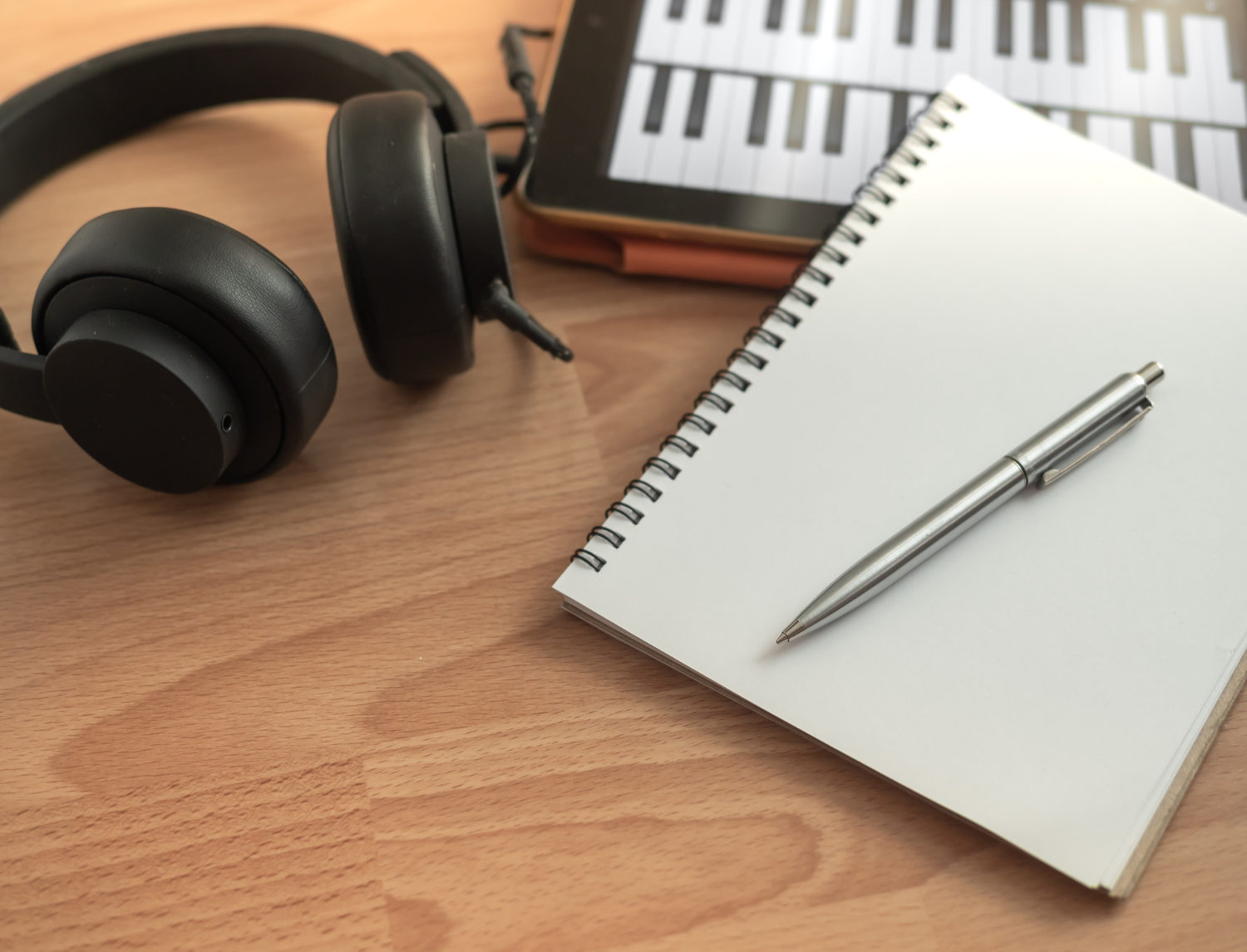 song writing headphones notepad piano and pen on table