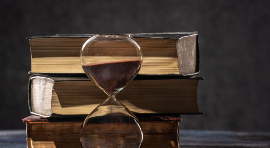 stack old books hourglass concept time knowledge