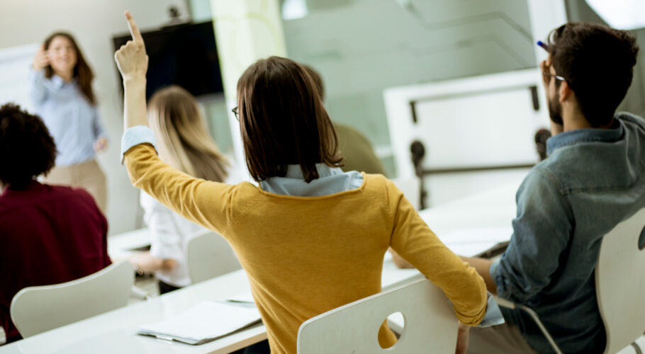 students during course in classroom raising hands answering training questions