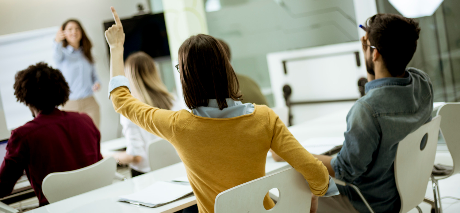 students during course in classroom raising hands answering training questions