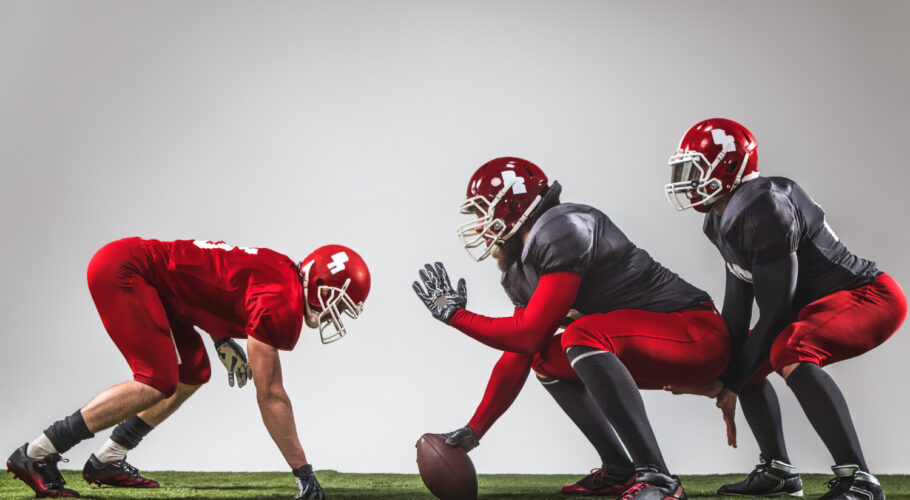 three american football players in Australia action green grass
