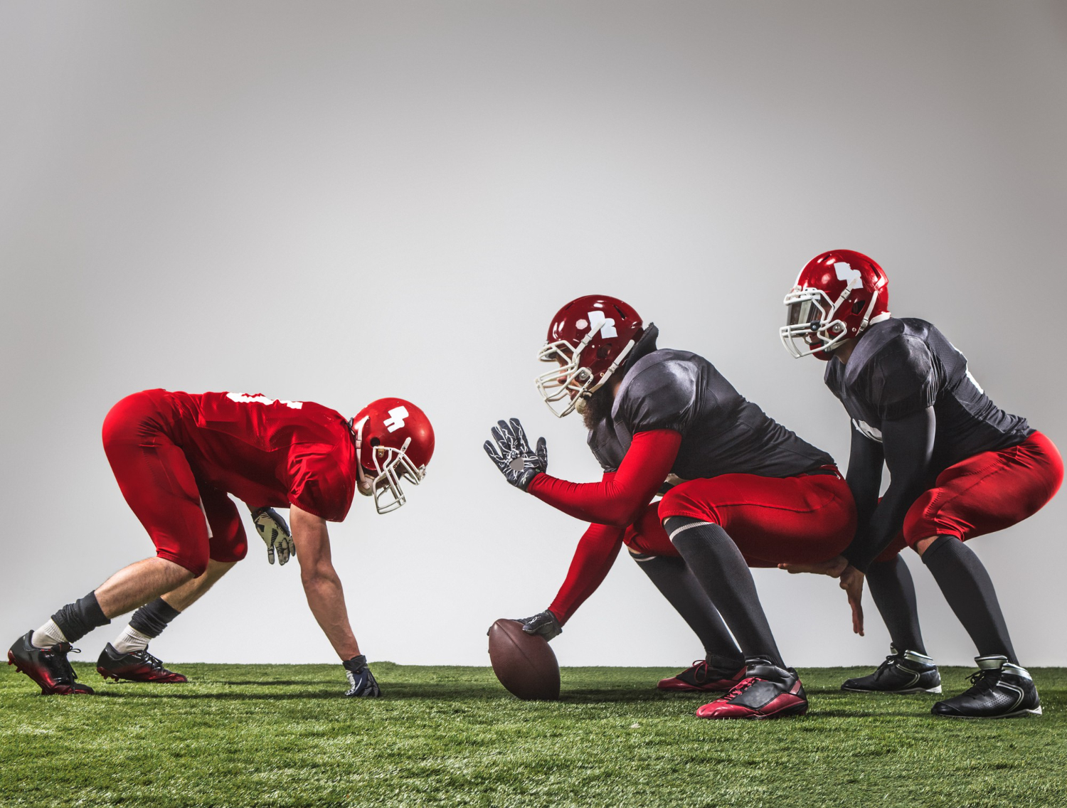 three american football players in Australia action green grass