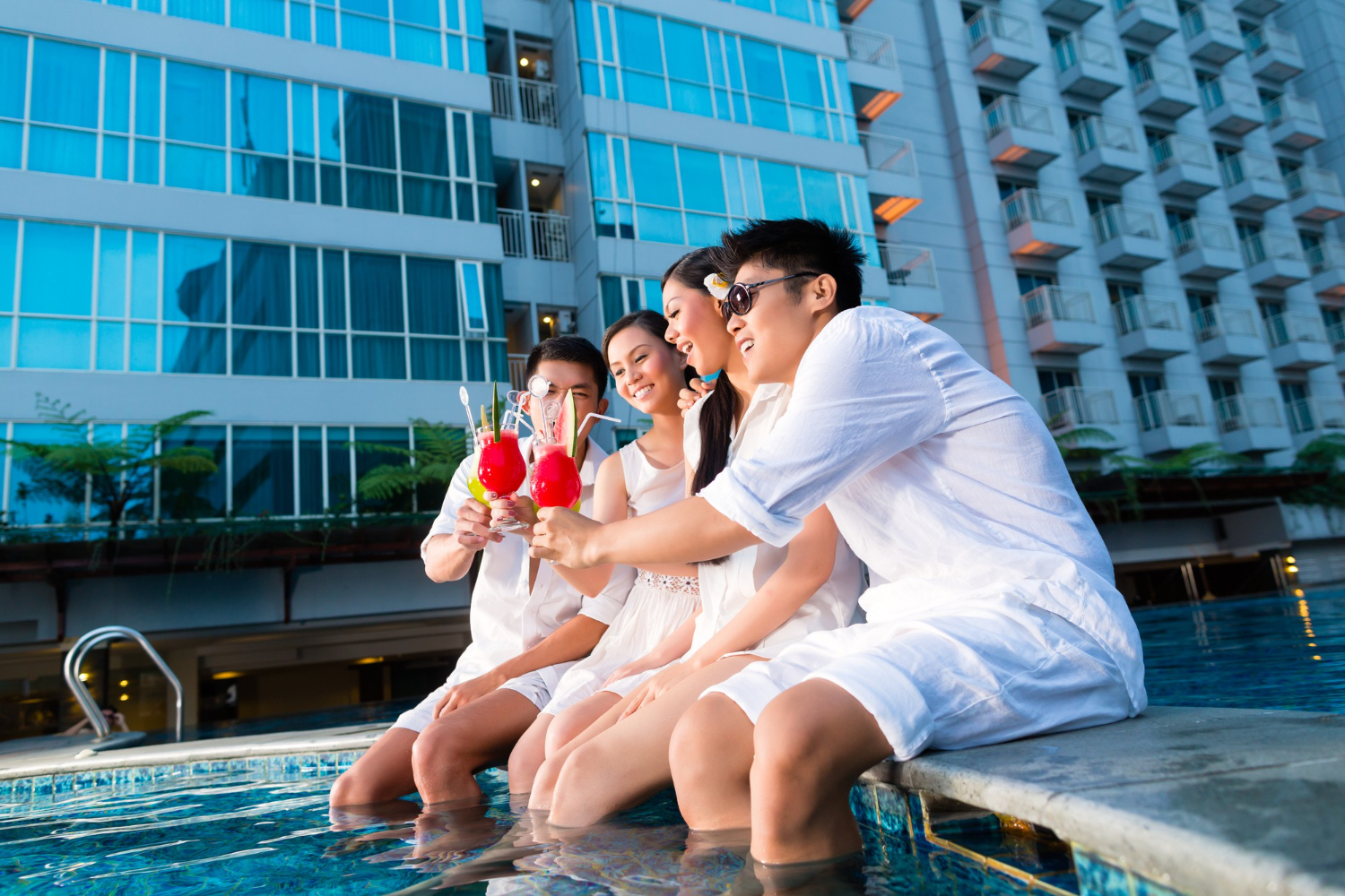 two young handsome asian chinese couples friends drinking cocktails luxurious fancy hotel pool bar