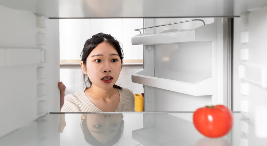upset chinese woman looking lonely tomato her fridge