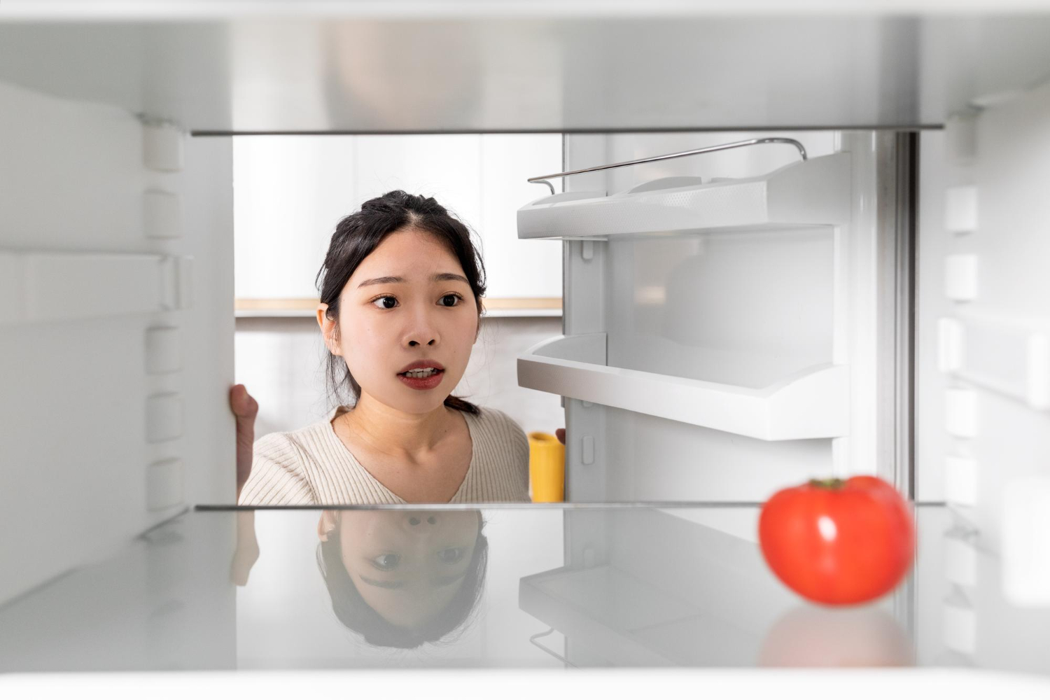upset chinese woman looking lonely tomato her fridge