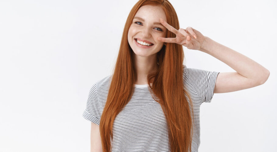 waist up shot friendly kind optimistic attractive young lucky teenage redhead girl blue eyes tilting head