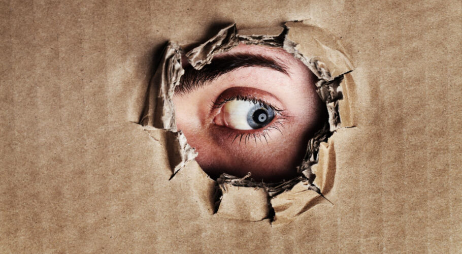 what is other side closeup anxiety depression panic portrait eye looking through ripped hole piece cardboard