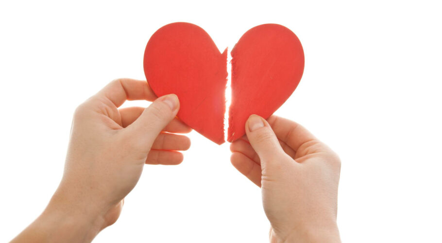 woman is holding two parts broken heart her hands front bright sky