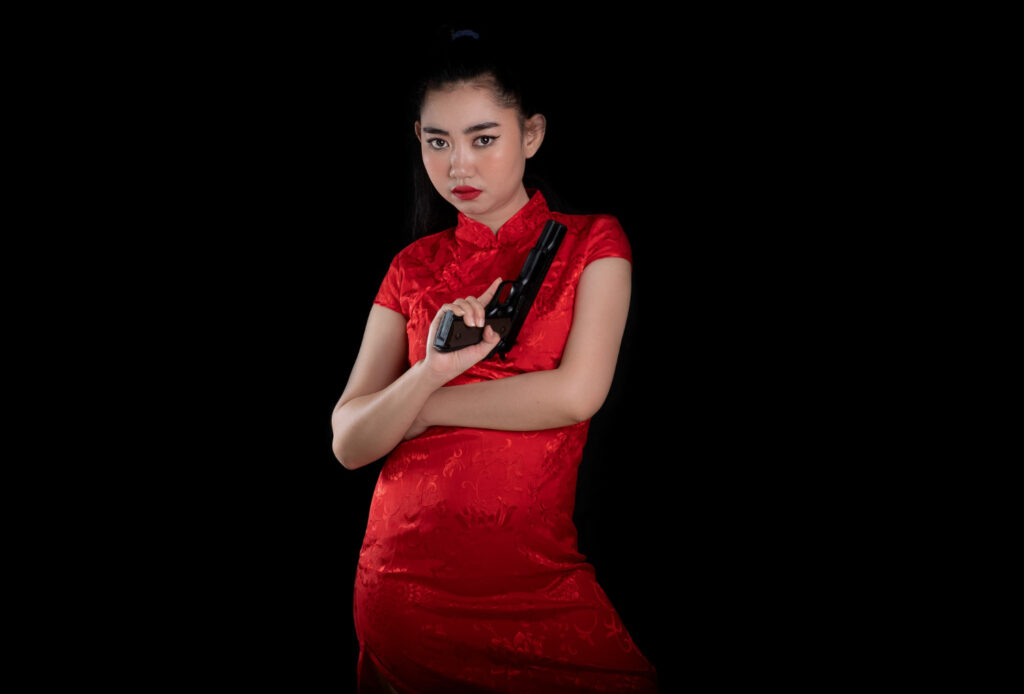 young asia woman red dress traditional cheongsam holding gun