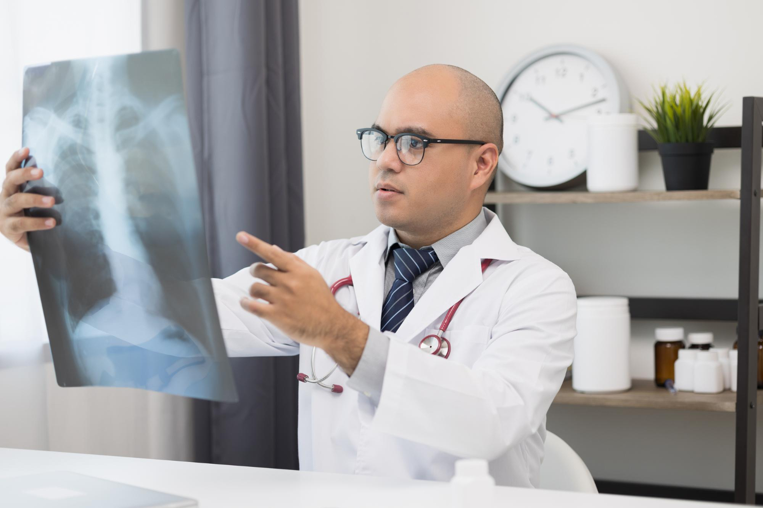 young asian doctor looking xray film patients symptoms from xray results are reported