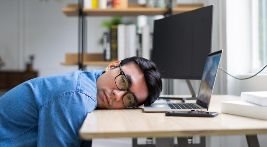 young stressed depressed overworked asian man working office