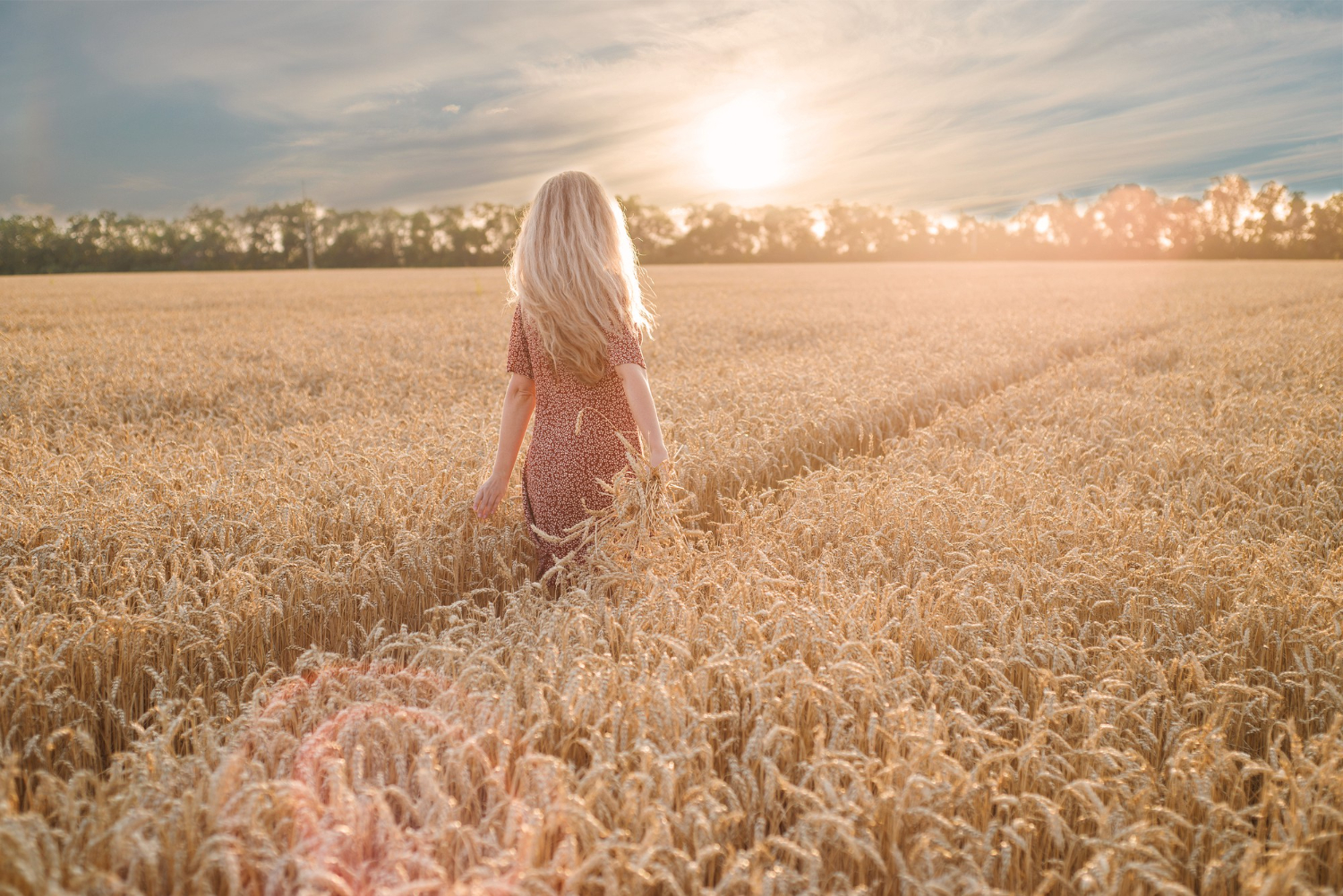 young blonde woman walking field with heat back view