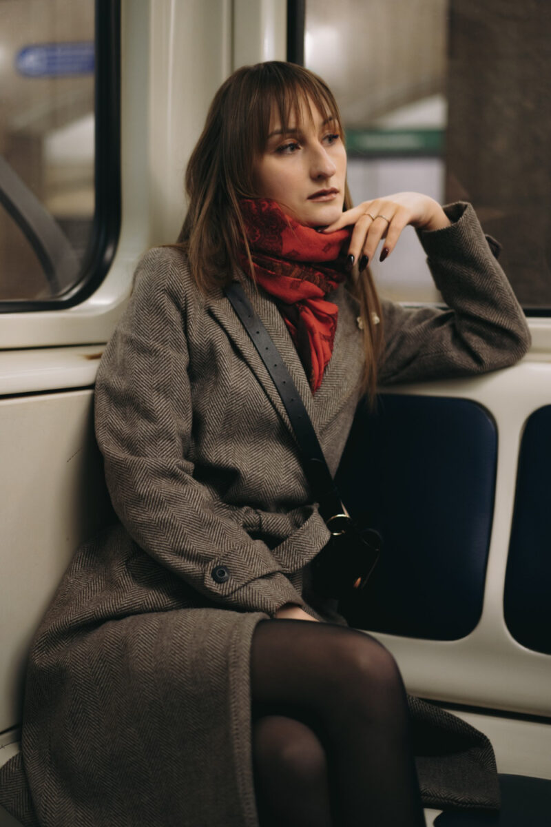 Young Brunette Lady In Coat On Train Looking Out Window