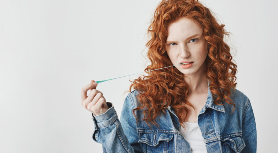 young cool redhead ginger woman with jean jacket chewing gum looking brutal