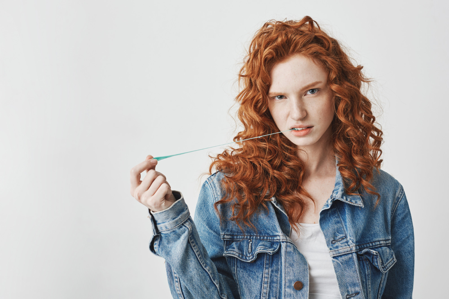 young cool redhead ginger woman with jean jacket chewing gum looking brutal