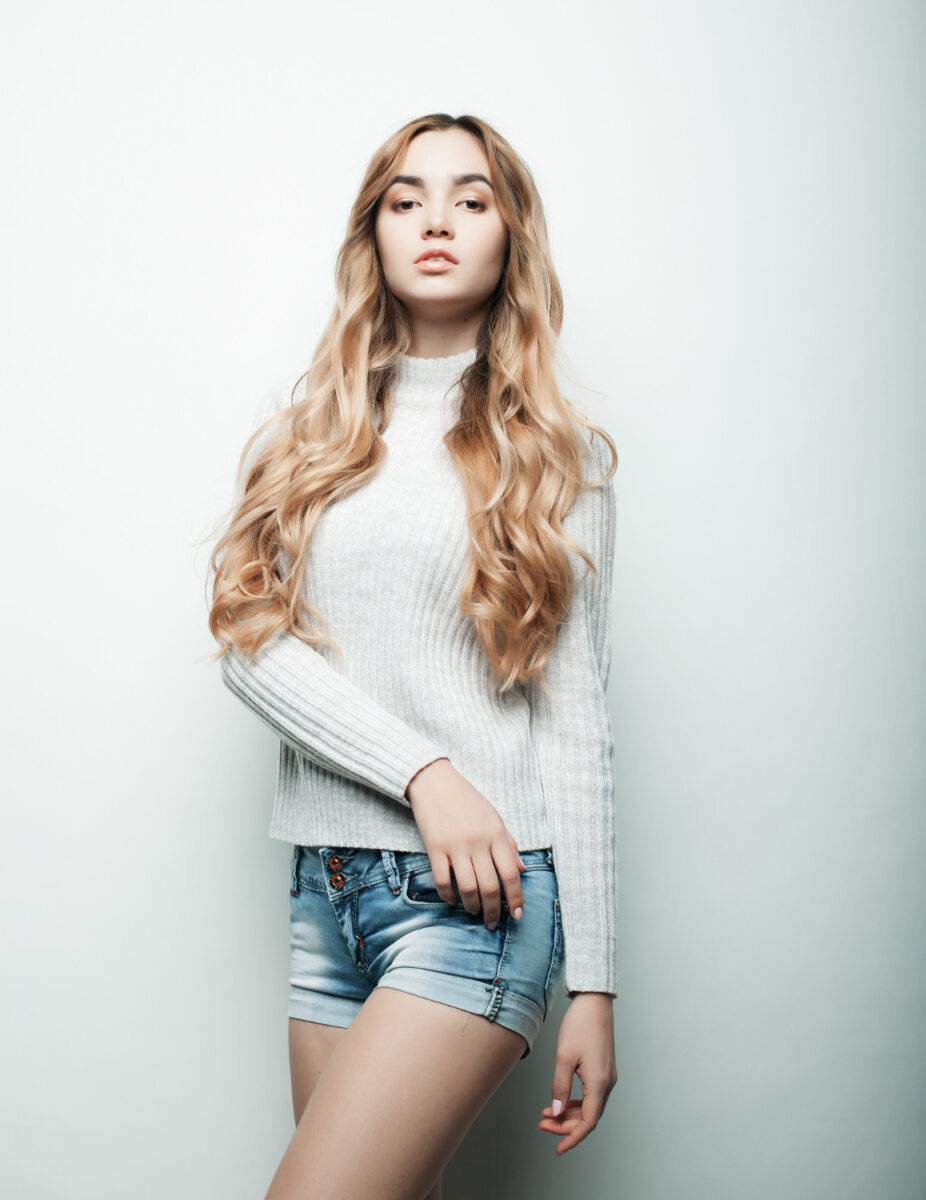 young woman tarina posing in white top and denim shorts